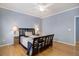 Comfortable bedroom with a dark wood bed frame, a blue and white quilt, and soft lighting from bedside lamps at 4211 Miners Candle Pl, Castle Rock, CO 80109