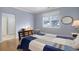 Bedroom with hardwood floors, light-blue walls, and a large window, complemented by a comfortable bed and dresser at 4211 Miners Candle Pl, Castle Rock, CO 80109