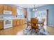 Cozy kitchen featuring wood cabinets, white appliances, and a breakfast nook with a round table and four chairs at 4211 Miners Candle Pl, Castle Rock, CO 80109