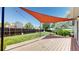 Expansive backyard featuring a wooden deck with shade sail, lush lawn, and privacy fence at 10950 Tennyson Ct, Westminster, CO 80031