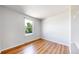 Bright bedroom with hardwood floors and a large window providing natural light; freshly painted neutral walls at 10950 Tennyson Ct, Westminster, CO 80031