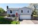 Charming two-story home featuring a red front door, well-manicured lawn, and blooming trees creating curb appeal at 10950 Tennyson Ct, Westminster, CO 80031