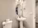 Powder room features a pedestal sink, oval mirror, and a toilet at 23545 E Platte Dr # C, Aurora, CO 80016