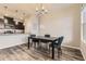 Dining area with a modern chandelier, a black table, and an open view into the kitchen at 23545 E Platte Dr # C, Aurora, CO 80016