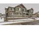 Inviting townhome exterior with green siding, stone accents and snowy front yard at 23545 E Platte Dr # C, Aurora, CO 80016