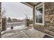 View of the front porch showing the stone columns, large window and wintry surroundings at 23545 E Platte Dr # C, Aurora, CO 80016