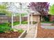 Charming backyard featuring a pergola, stone patio, raised garden beds, and lush landscaping at 401 S Williams St, Denver, CO 80209