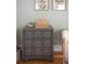 Bedroom detail of an antique side table with drawers and decor, located next to a comfy chair at 401 S Williams St, Denver, CO 80209