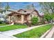 Charming brick home featuring a cozy front porch, manicured lawn, and mature trees at 401 S Williams St, Denver, CO 80209
