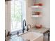 Close up of a farmhouse sink, stainless steel faucet, marble countertops, and subway tile backsplash at 401 S Williams St, Denver, CO 80209