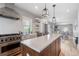Bright kitchen showcases a stainless steel stove, farmhouse sink, white cabinets, and island with quartz countertops at 401 S Williams St, Denver, CO 80209