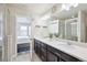 Bathroom with double sinks, dark cabinets, and glass shower door at 2395 S Troy Ct, Aurora, CO 80014