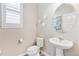 Elegant powder room with pedestal sink, modern fixtures and oval mirror at 2395 S Troy Ct, Aurora, CO 80014