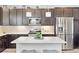 Bright kitchen featuring a quartz island, stainless steel appliances, and ample storage in the dark wood cabinetry at 2395 S Troy Ct, Aurora, CO 80014