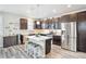 Modern kitchen featuring stainless steel appliances, dark wood cabinets, quartz countertops, and a stylish island at 2395 S Troy Ct, Aurora, CO 80014