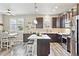 Well-lit kitchen featuring a center island with seating, stainless steel appliances, and an adjacent dining area at 2395 S Troy Ct, Aurora, CO 80014