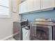 Laundry room with front-loading washer and dryer and white cabinets at 2395 S Troy Ct, Aurora, CO 80014