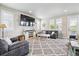 Comfortable living room with ample seating, large TV, plush rug, and natural light from the adjacent windows at 2395 S Troy Ct, Aurora, CO 80014