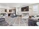 Open-concept living room with a large TV, plush rug, and an open flow into the modern kitchen at 2395 S Troy Ct, Aurora, CO 80014