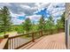 Expansive wood deck with natural views showcasing lush trees and beautiful blue sky at 10436 Jeanette Ct, Morrison, CO 80465