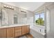 Bathroom with double sink vanity, soaking tub, and separate glass-enclosed shower at 5796 E 129Th Pl, Thornton, CO 80602