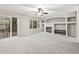 Bright living room featuring plush carpeting, ceiling fan, fireplace, and sliding door to balcony at 5796 E 129Th Pl, Thornton, CO 80602