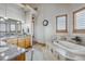 Relaxing bathroom with dual sinks, wood cabinets, a soaking tub, tile floors, and lots of natural light at 11624 Dunrich Rd, Parker, CO 80138
