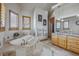 Luxurious bathroom with tiled floors, a soaking tub, wood cabinets, granite counters, and modern fixtures at 11624 Dunrich Rd, Parker, CO 80138