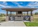 Covered outdoor kitchen area with a fireplace, comfortable seating, and a beautiful view at 11624 Dunrich Rd, Parker, CO 80138