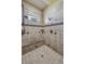 Detailed stone shower with a built-in bench, dual shower heads, and a window for natural light at 11624 Dunrich Rd, Parker, CO 80138