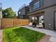 Inviting backyard with well-maintained lawn, patio seating, privacy fence, and modern home exterior at 1612 Wolff St, Denver, CO 80204