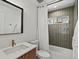 Modern bathroom with sleek vanity, a large framed mirror, and a shower-tub combo with tiled wall at 1612 Wolff St, Denver, CO 80204