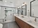 Bathroom boasting double sinks, modern mirrors, and glass-enclosed shower at 1612 Wolff St, Denver, CO 80204
