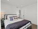 Cozy bedroom with a black metal bed frame, soft bedding, and soothing decor with an ensuite bathroom at 1612 Wolff St, Denver, CO 80204