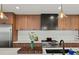 Modern kitchen features wood cabinets, a stainless steel range, and a dark vent hood at 1612 Wolff St, Denver, CO 80204