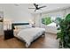 Well-lit main bedroom with a large window, ceiling fan, and hardwood floors at 1612 Wolff St, Denver, CO 80204