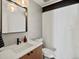 Bright half-bathroom with tile accent wall and light fixture at 1612 Wolff St, Denver, CO 80204