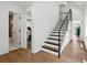 Modern staircase with wood treads, black risers and railing, connecting levels of the home at 1612 Wolff St, Denver, CO 80204