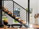 A close up view of a modern stair case with metal handrails and a view to the outside at 1612 Wolff St, Denver, CO 80204