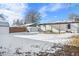 Spacious backyard with a covered patio, storage shed, and snowy landscape at 9300 Grove St, Westminster, CO 80031