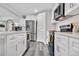 Modern kitchen with white cabinets, stainless steel appliances, and quartz countertops at 9300 Grove St, Westminster, CO 80031