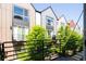 A lovely view from a modern home's balcony overlooking lush trees and charming multi-story townhomes at 5630 W 11Th Pl, Lakewood, CO 80214