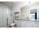 Modern bathroom featuring a glass-enclosed shower, sleek vanity, and ample natural light at 5630 W 11Th Pl, Lakewood, CO 80214