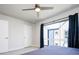 Bright bedroom with blue curtains framing a window, and a modern ceiling fan at 5630 W 11Th Pl, Lakewood, CO 80214