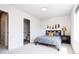 Bright bedroom featuring neutral carpet, a decorative lamp, and ensuite bathroom access at 5630 W 11Th Pl, Lakewood, CO 80214