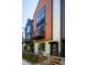 Modern townhome exterior with a combination of metal and siding facade, front porch, and wood railing at 5630 W 11Th Pl, Lakewood, CO 80214