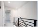 Bright, neutrally decorated hallway with gray carpet and black railings, leading to various rooms at 5630 W 11Th Pl, Lakewood, CO 80214