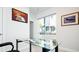 Bright home office space featuring a glass desk, modern artwork, and a window at 5630 W 11Th Pl, Lakewood, CO 80214