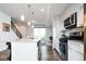 Open concept kitchen with stainless steel appliances, wood floors, a breakfast bar, and easy access to the outdoor patio at 5630 W 11Th Pl, Lakewood, CO 80214