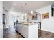 Modern kitchen with stainless steel appliances, sleek cabinets, an island with a breakfast bar, and a view into the dining area at 5630 W 11Th Pl, Lakewood, CO 80214